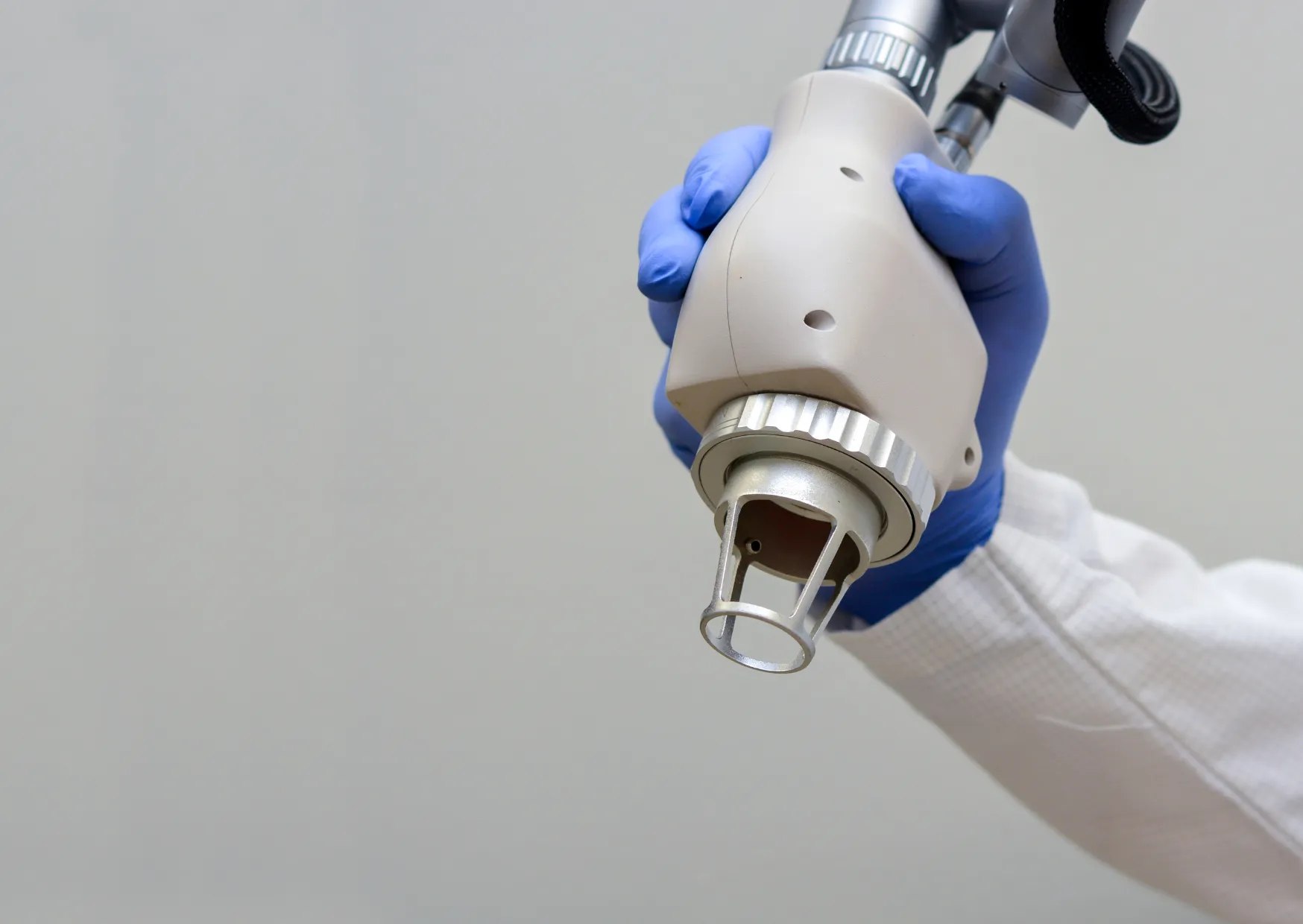 Close-up of a medical-grade HELIX CO2 laser handpiece positioned near a patient's face for acne scar resurfacing.